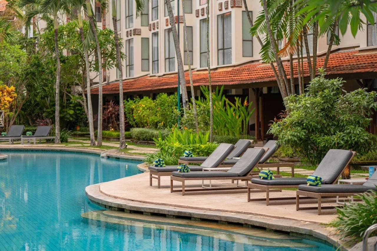 a row of lounge chairs next to a swimming pool at Prime Plaza Hotel Sanur \u2013 Bali in Sanur