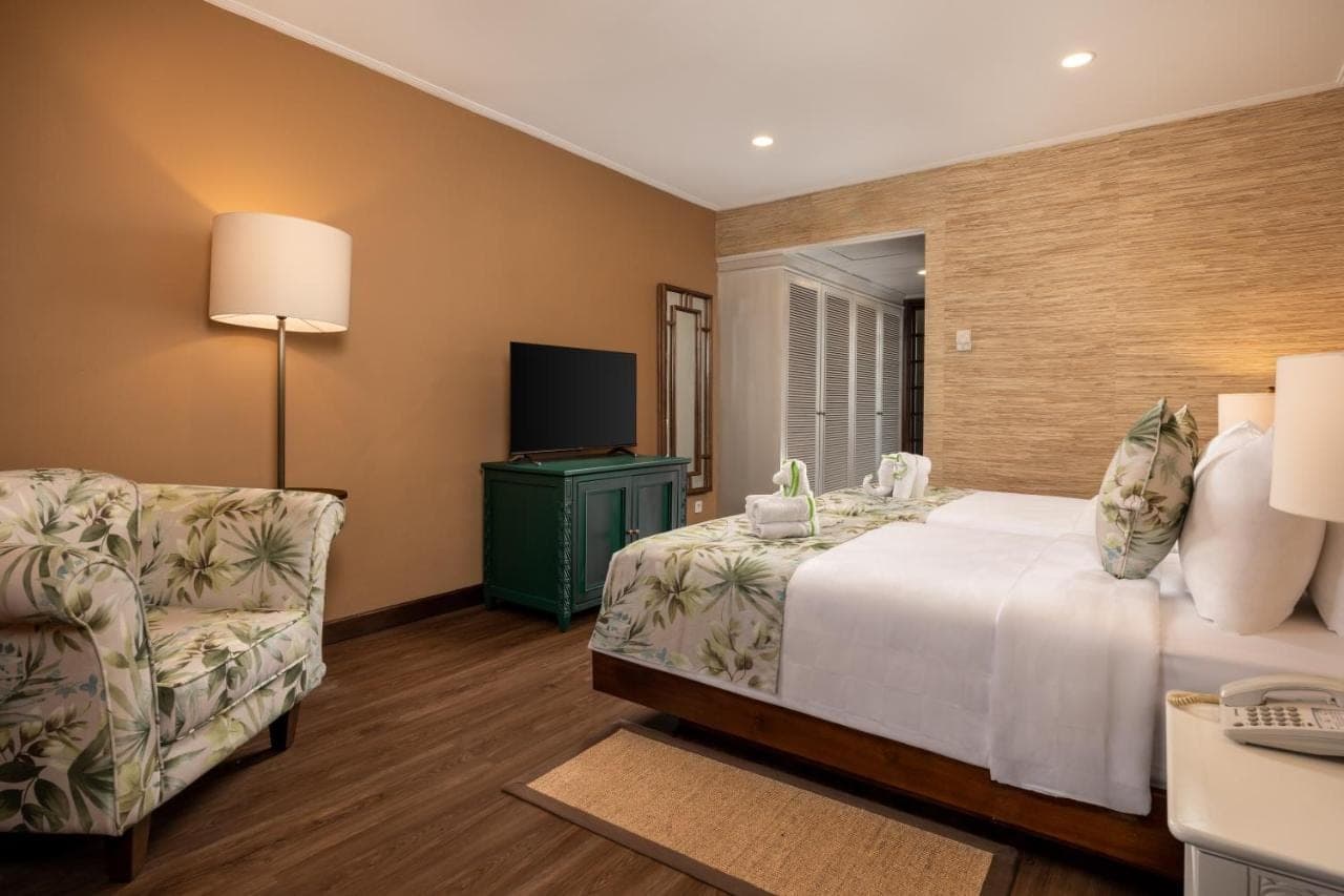 a hotel room with a bed and a chair at Prime Plaza Hotel Sanur \u2013 Bali in Sanur