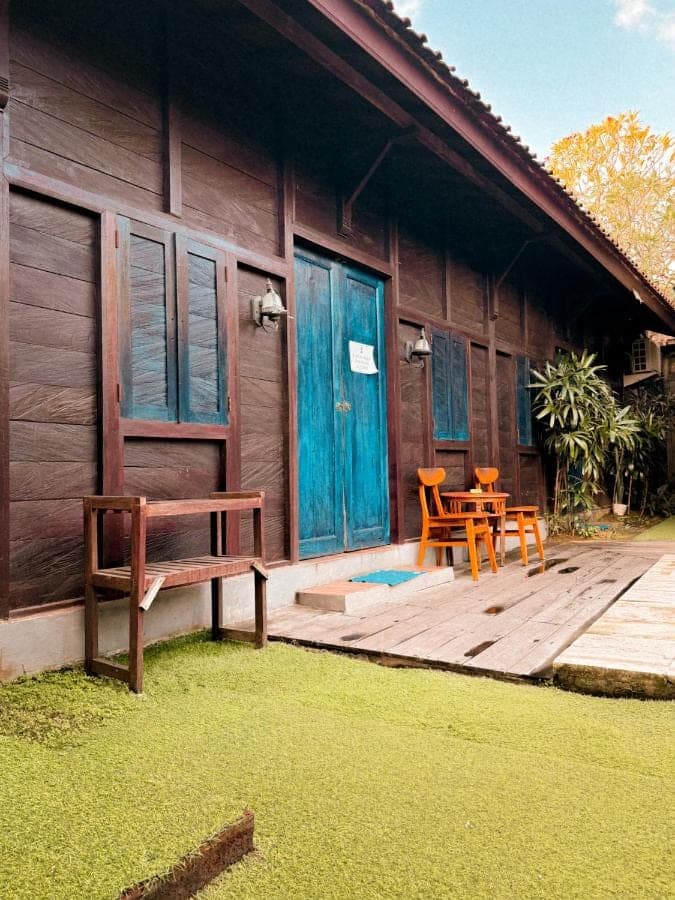 a house with a deck with two chairs and a table at The Tipsy Gypsy Hostel in Canggu