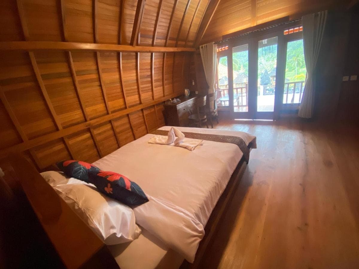 a bedroom with two beds in a room with windows at Sri Sedana Homestay in Sidemen