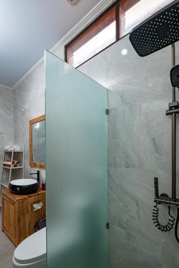 a bathroom with a shower and a toilet at Kemala Living Sanur in Sanur