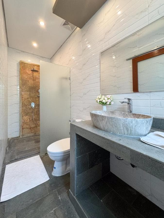 a bathroom with a sink and a toilet at Indara private pool villa in Nusa Dua