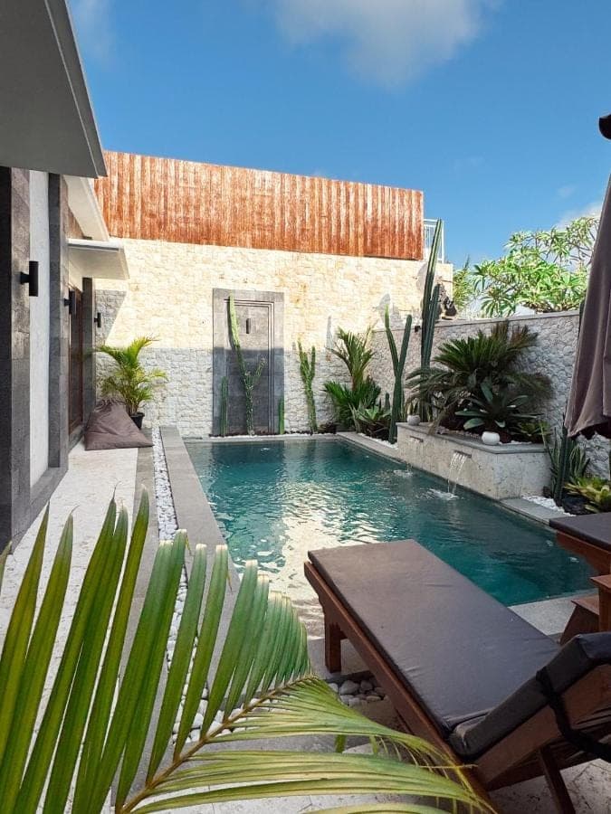 a swimming pool in front of a house at Indara private pool villa in Nusa Dua