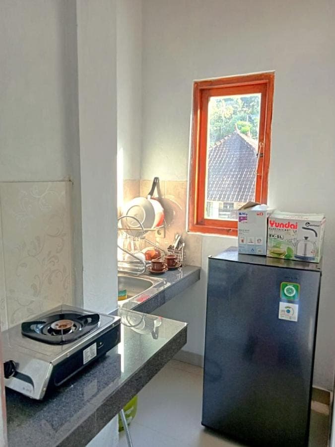 a small kitchen with a stove and a refrigerator at Raweg Studio in Amed