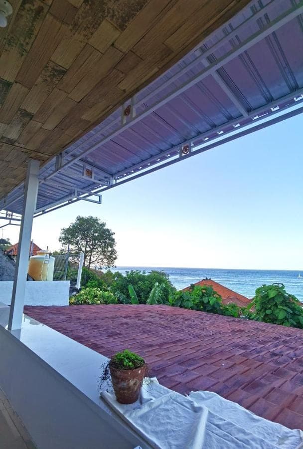 a patio with a roof with a potted plant on it at Raweg Studio in Amed