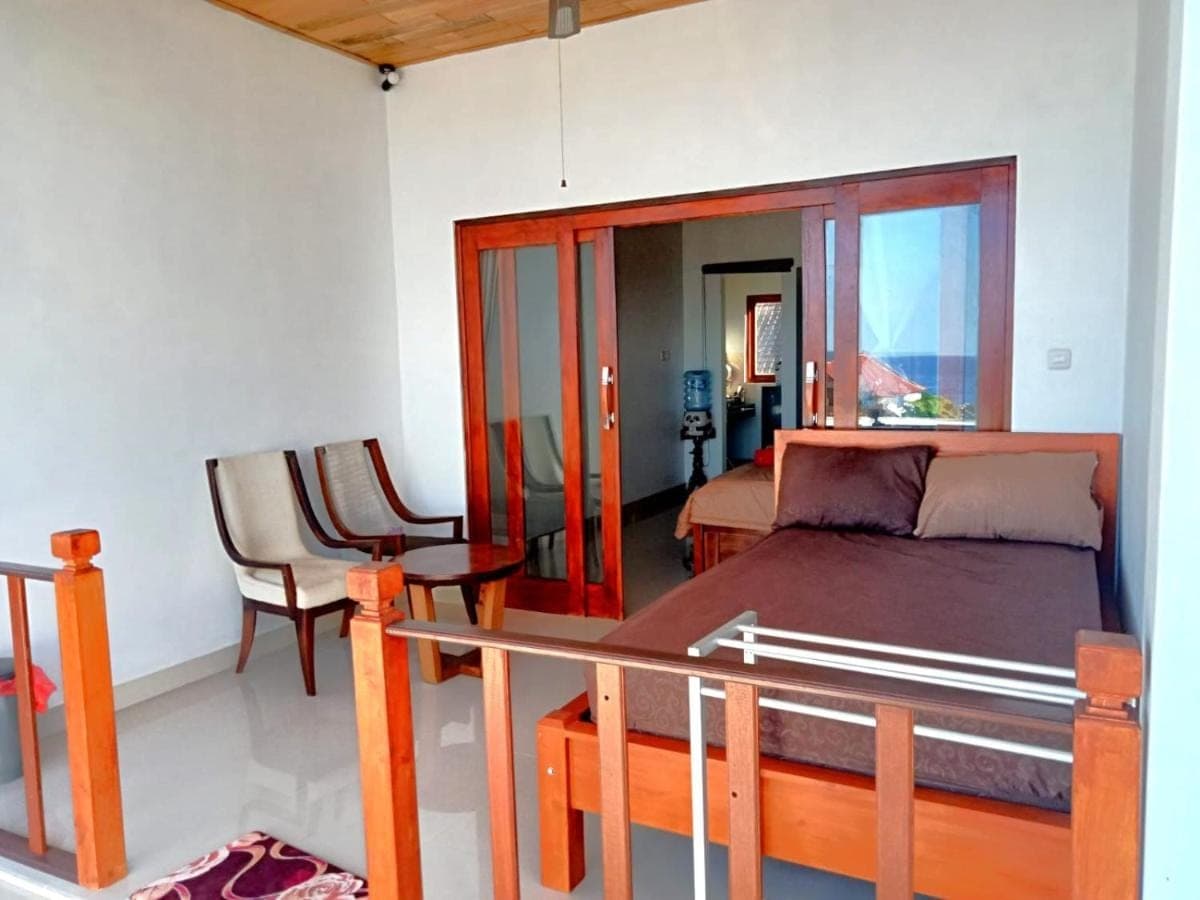 a bedroom with a bed and a table and a chair at Raweg Studio in Amed