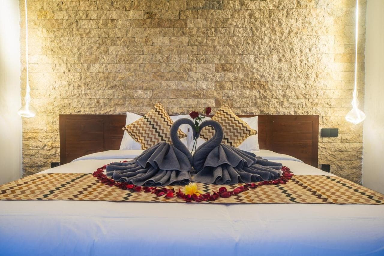 a bed with two swans dressed in black at 3Bedroom - 703 - Private Pool Villa Sanur in Sanur