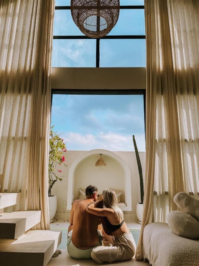 a man and woman kissing in front of a window at Villa Indah Rose Canggu Bali in Canggu