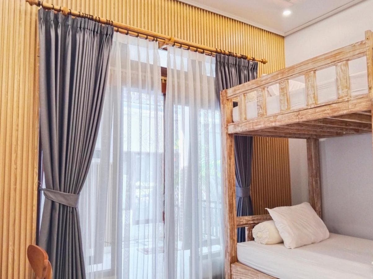 a bedroom with two bunk beds and a window at Sama Sama Amed in Amed