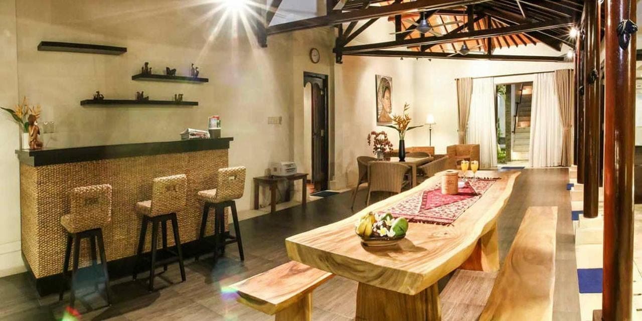 a dining room with a wooden table and chairs at Linda Villa Sanur by Linda in Sanur