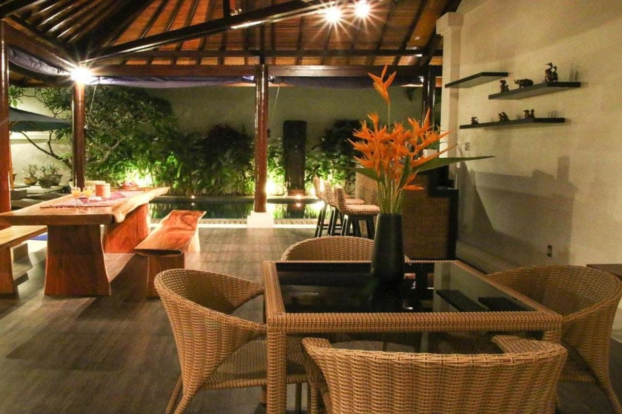 a dining room with chairs and a table with a glass table at Linda Villa Sanur by Linda in Sanur