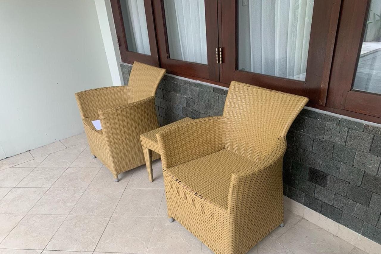 three wicker chairs sitting next to a wall at Linda Villa Sanur by Linda in Sanur