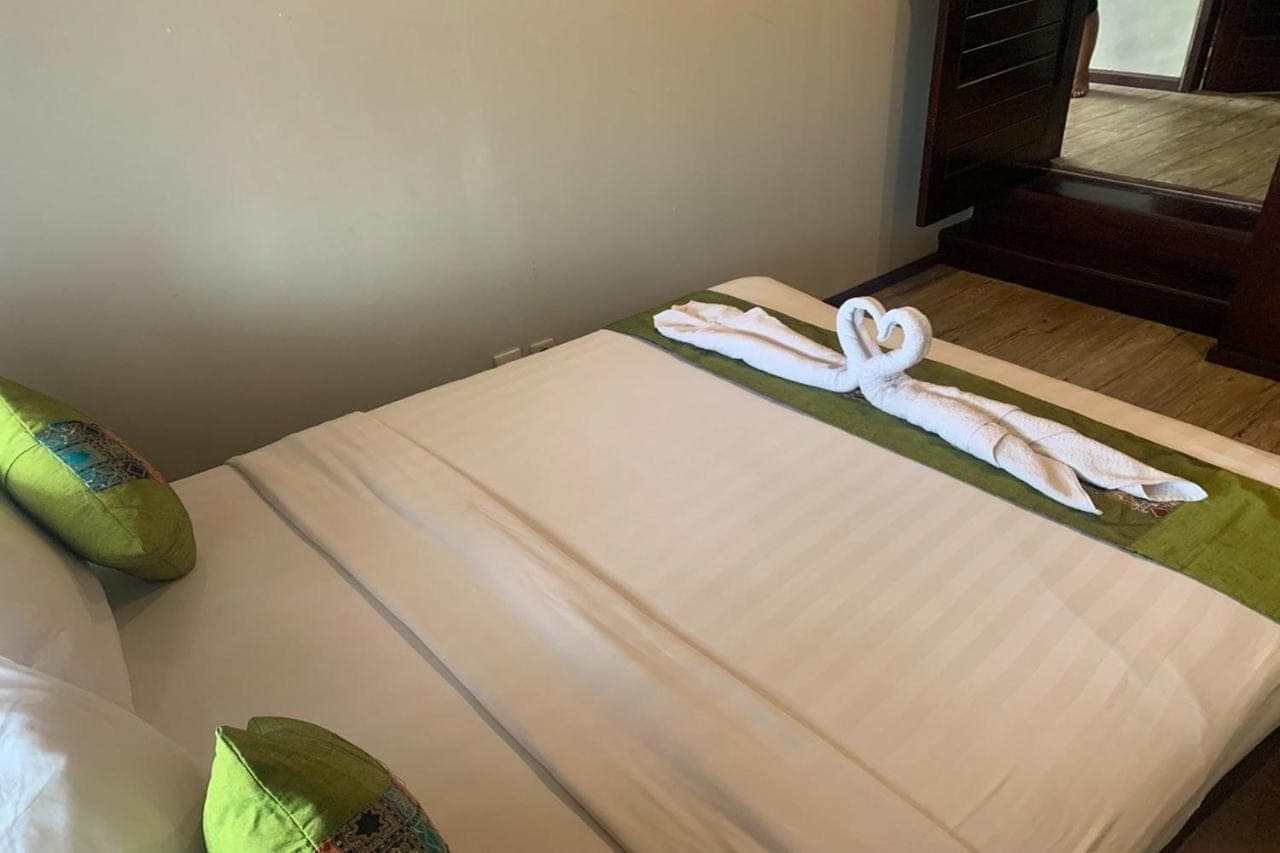 a bed with two towels on top of it at Linda Villa Sanur by Linda in Sanur