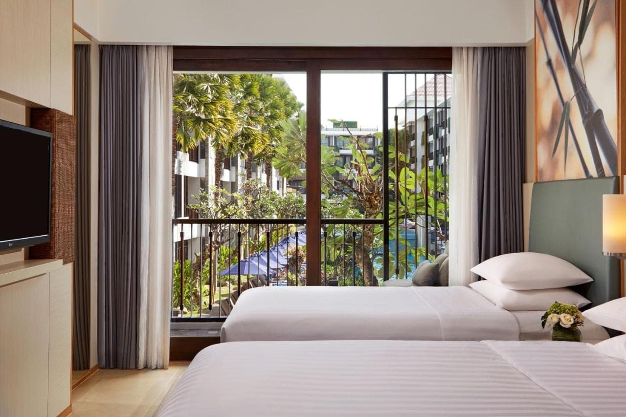 a hotel room with two beds and a large window at Courtyard by Marriott Bali Seminyak Resort in Seminyak