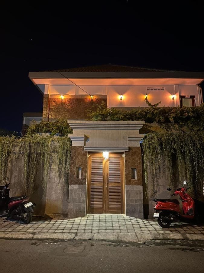 a house with two motorcycles parked in front of a garage at Sekuta 36 in Sanur