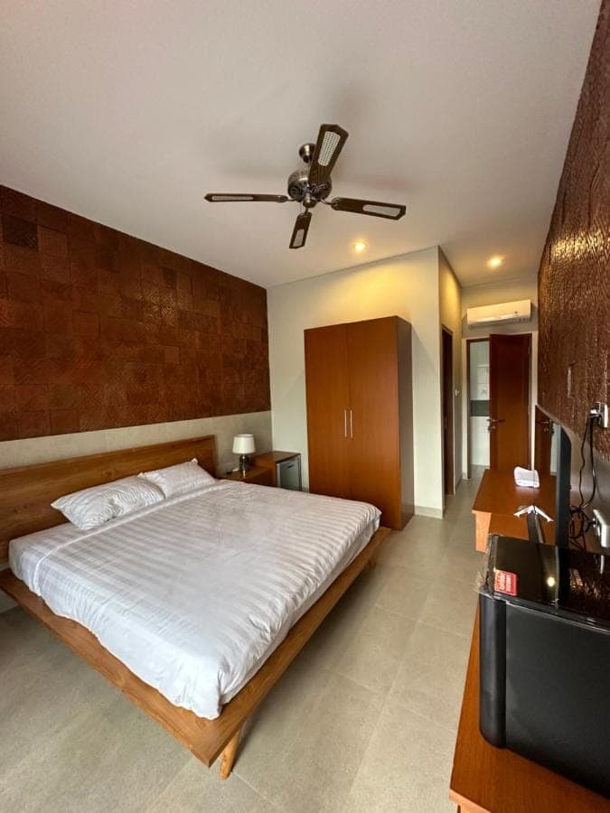 a bedroom with a bed and a ceiling fan at Sekuta 36 in Sanur