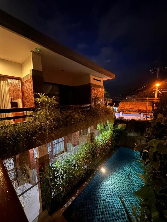 a swimming pool in front of a house at night at Sekuta 36 in Sanur