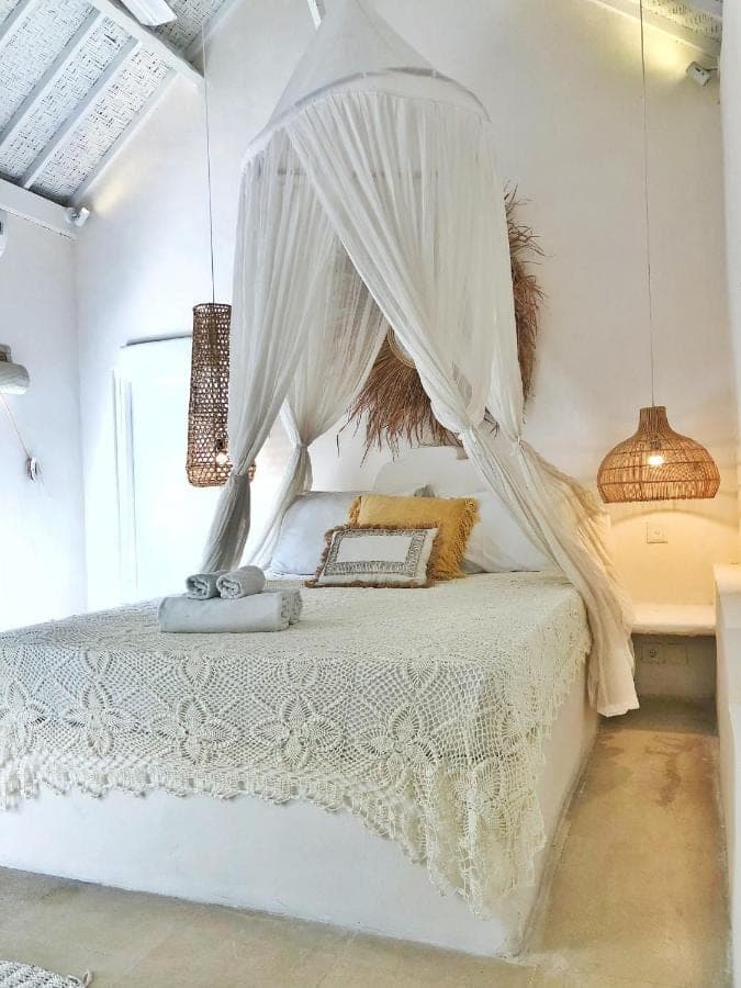 a bedroom with a white bed with a canopy at Sal Secret Spot in Uluwatu