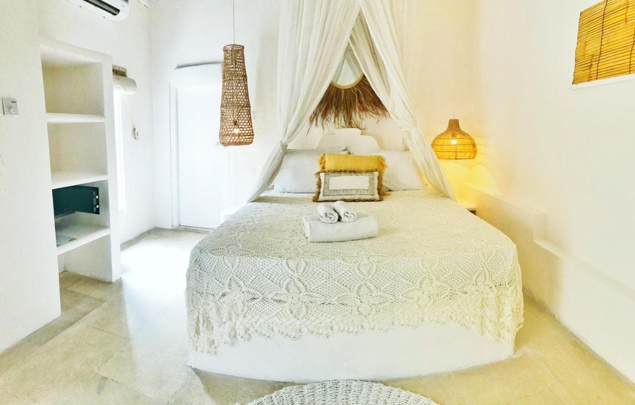 a bedroom with a white bed with two towels on it at Sal Secret Spot in Uluwatu