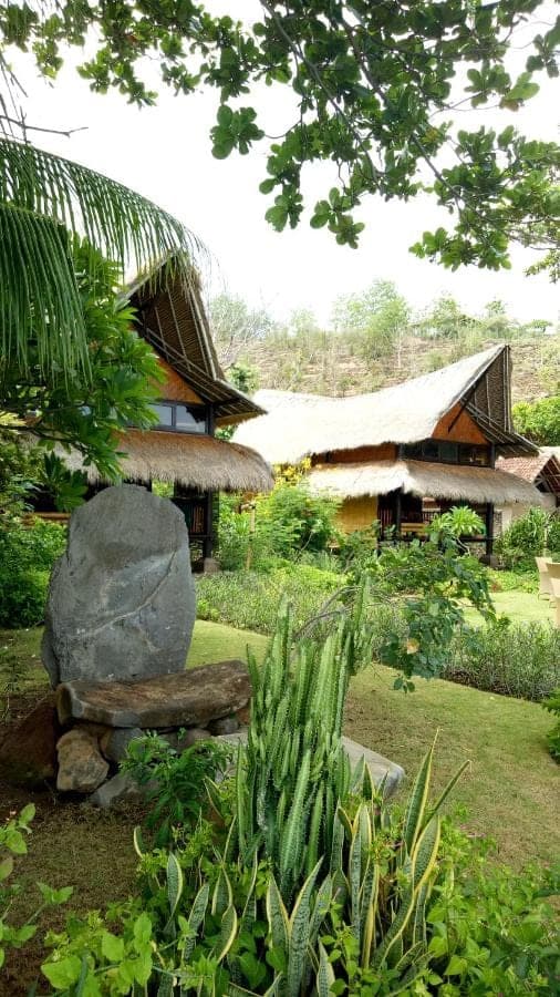 a house with a large rock in front of it at Good Karma Bungalows in Amed