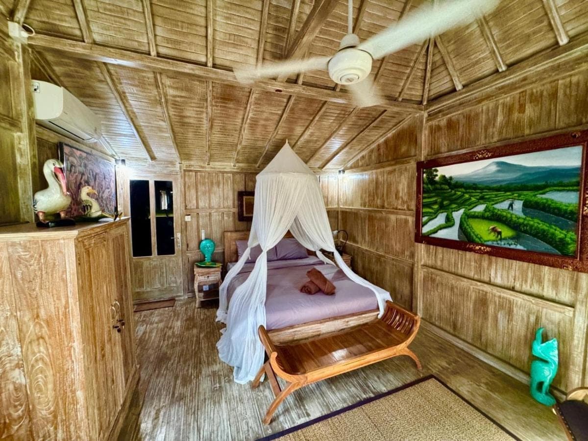 a bedroom with a bed in a tree house at Junjungan Suite in Ubud