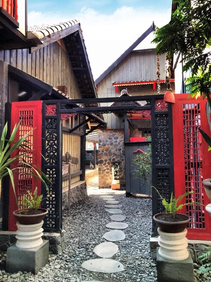 a pathway in front of a building with red gates at Amed Lodge by Sudamala Resorts in Amed