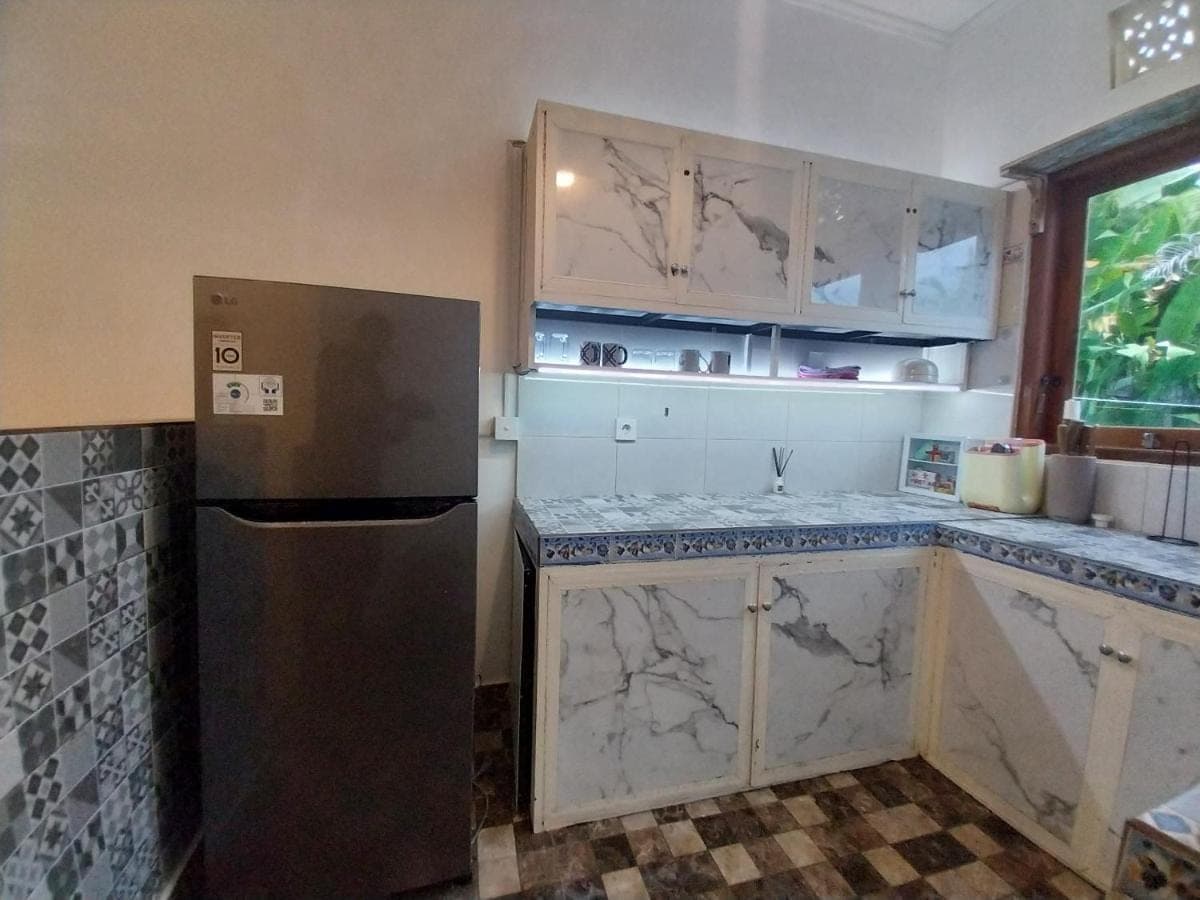 a kitchen with marble counter tops and a refrigerator at D,Jajang Guest House in Nusa Dua
