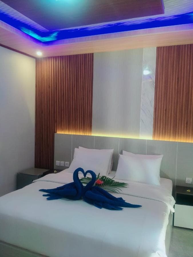 a bed with a blue ribbon sitting on top of it at Coral Bay Bungalows Amed Bali in Amed