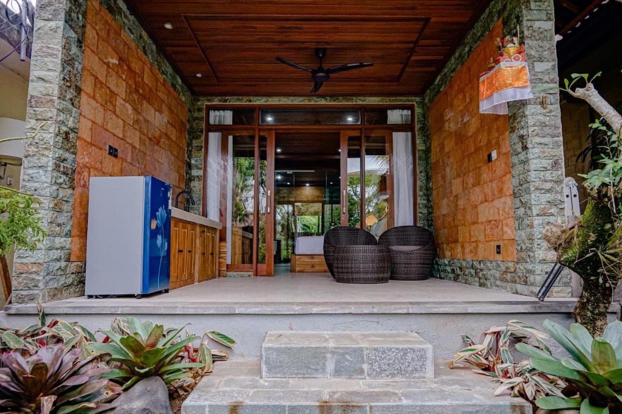 an entrance to a house with a blue refrigerator at Pekak Mangku Guest House in Ubud
