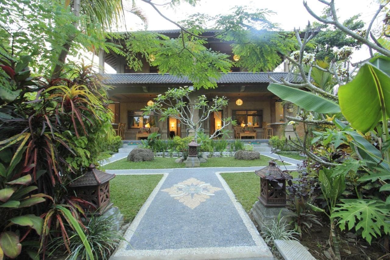 a house with a garden in front of it at Pekak Mangku Guest House in Ubud