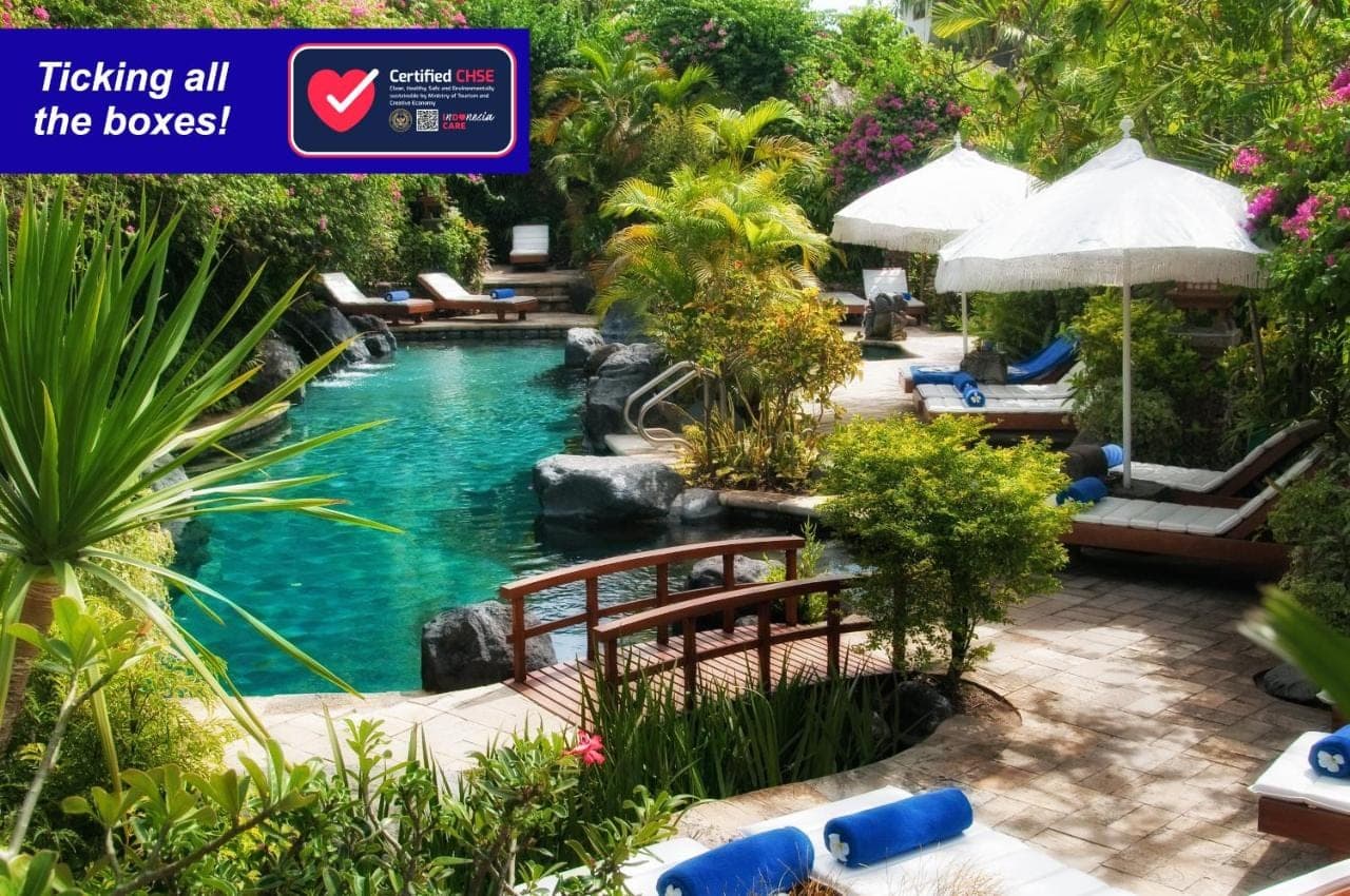 a pool at a resort with a sign that reads picking all the boxes at Poppies Bali in Kuta