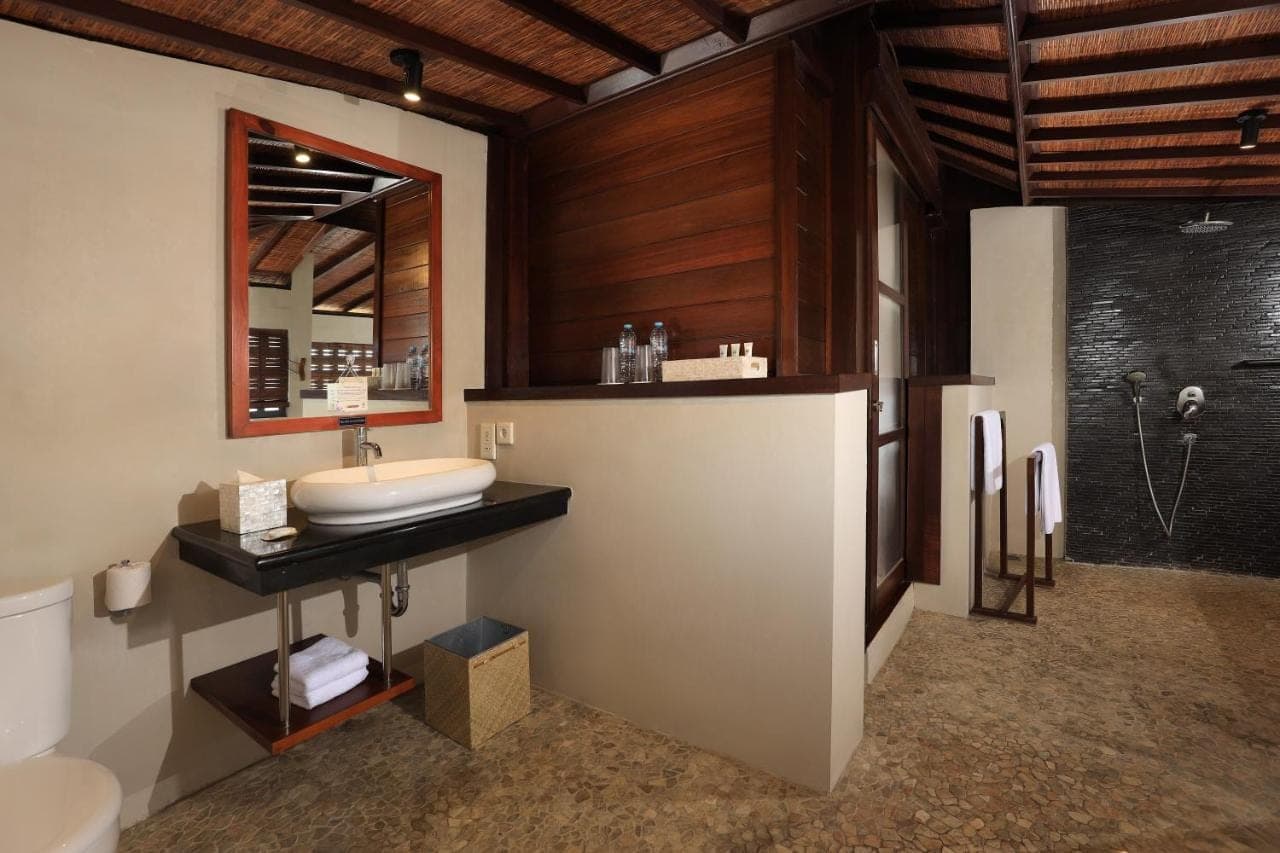 a bathroom with a sink and a mirror and a shower at Amadea Resort & Villas Seminyak Bali in Seminyak