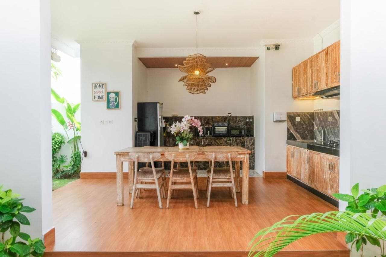 a kitchen and dining room with a wooden table and chairs at The Lavana Hi Inn Uluwatu in Uluwatu
