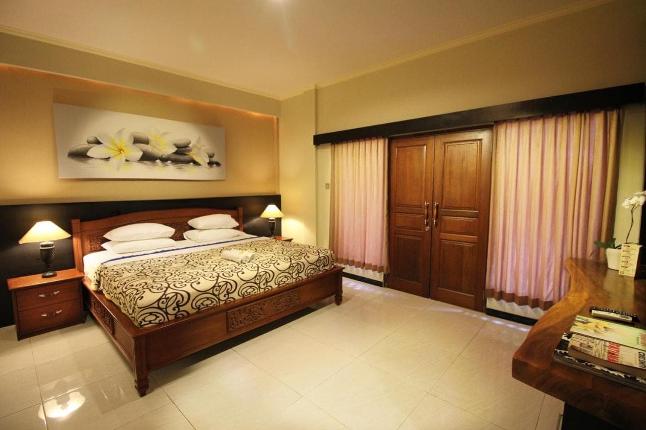 a bedroom with a bed and a painting on the wall at Jepun Bali Hotel in Kuta