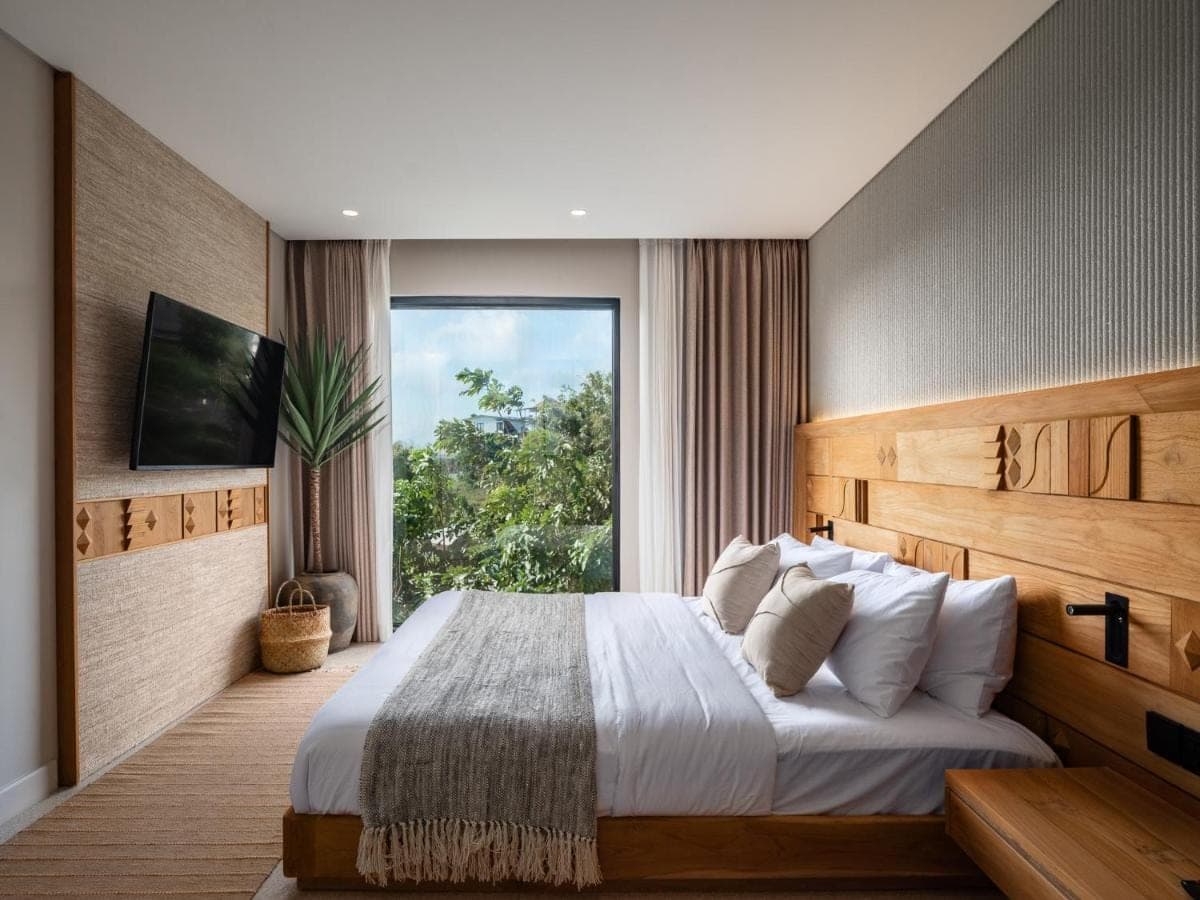 a bedroom with a large bed with a large window at Mira Hotel & Recovery - Sauna & Ice Bath in Uluwatu