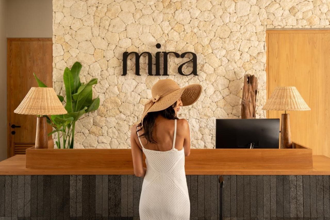 a woman wearing a hat standing in front of a counter at Mira Hotel & Recovery - Sauna & Ice Bath in Uluwatu