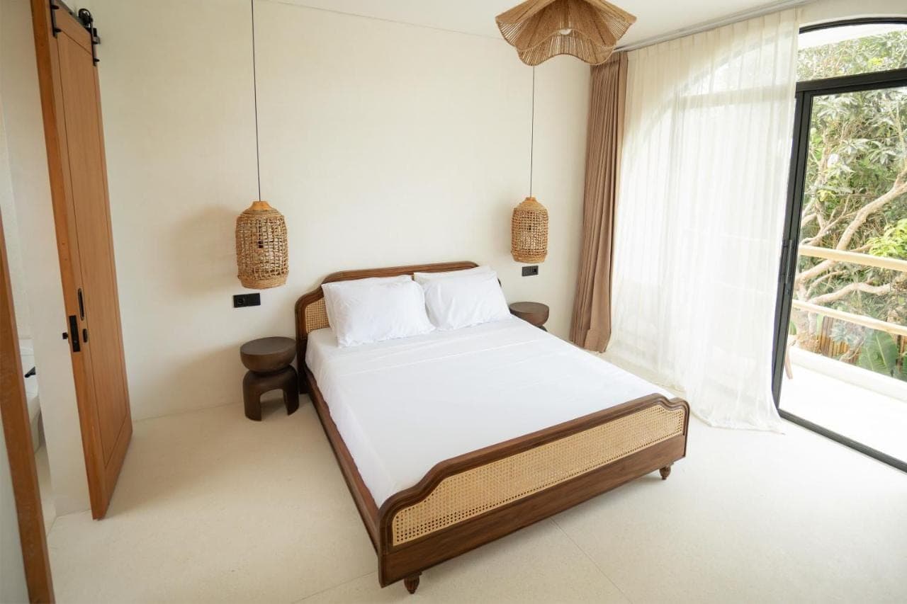 a bedroom with a bed and a window at Tyde Bali Boutique Hotel in Uluwatu