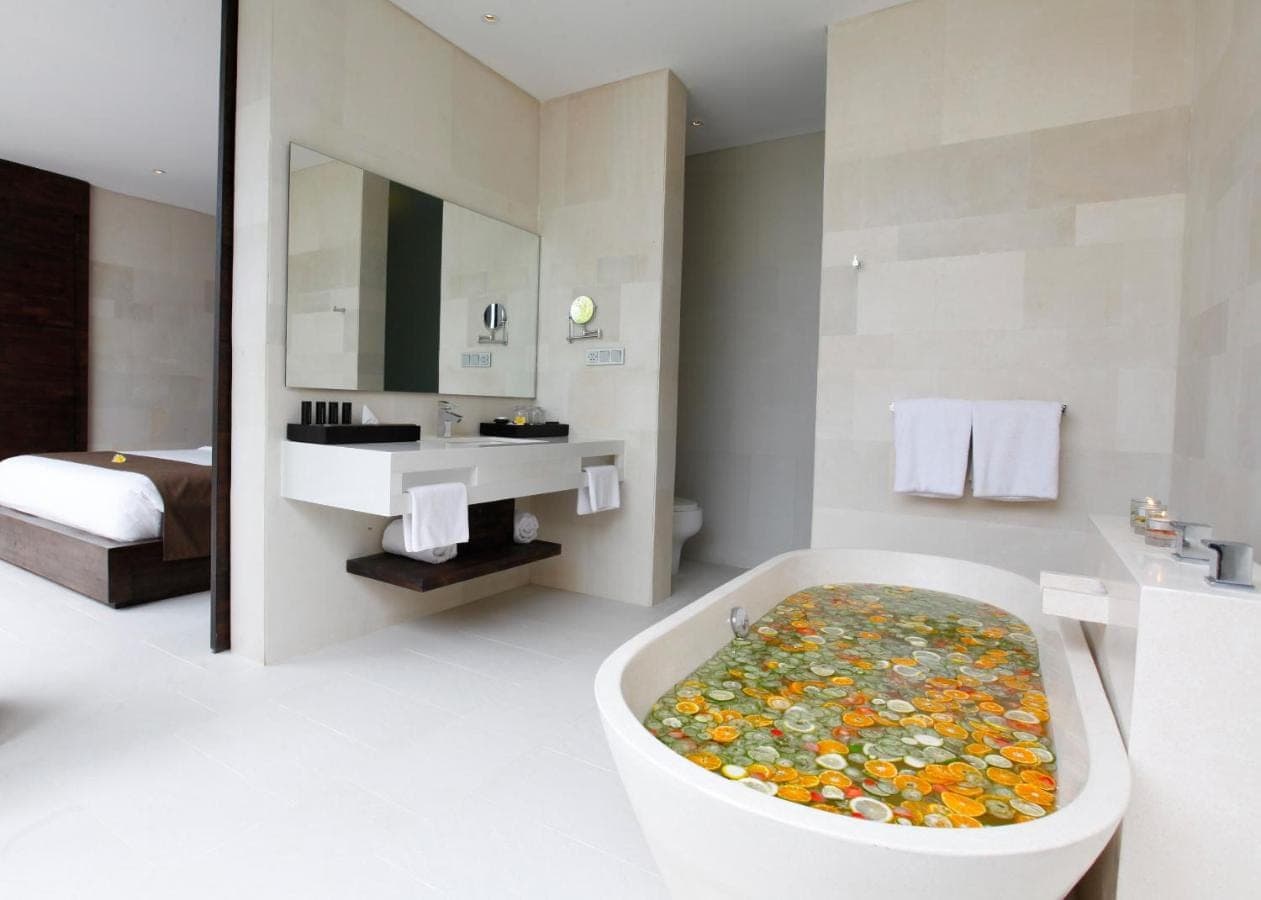 a bathroom with a bath tub filled with lots of flowers at eqUILIBRIA Seminyak in Seminyak