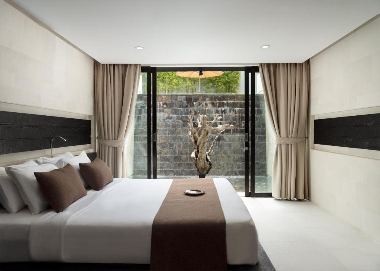 a bedroom with a large bed and a large window at eqUILIBRIA Seminyak in Seminyak