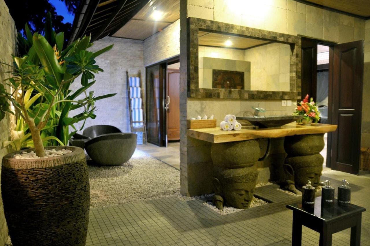 a bathroom with a sink and a large mirror at Hidden Paradise Cottages in Amed