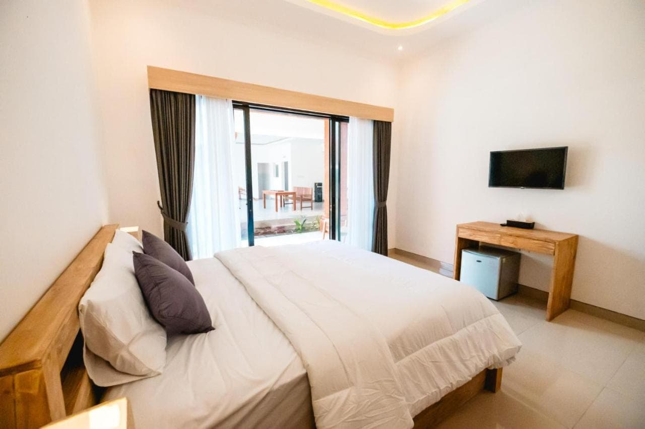 a bedroom with a large bed and a window at Kubu Dangin Guest House Kerobokan in Seminyak