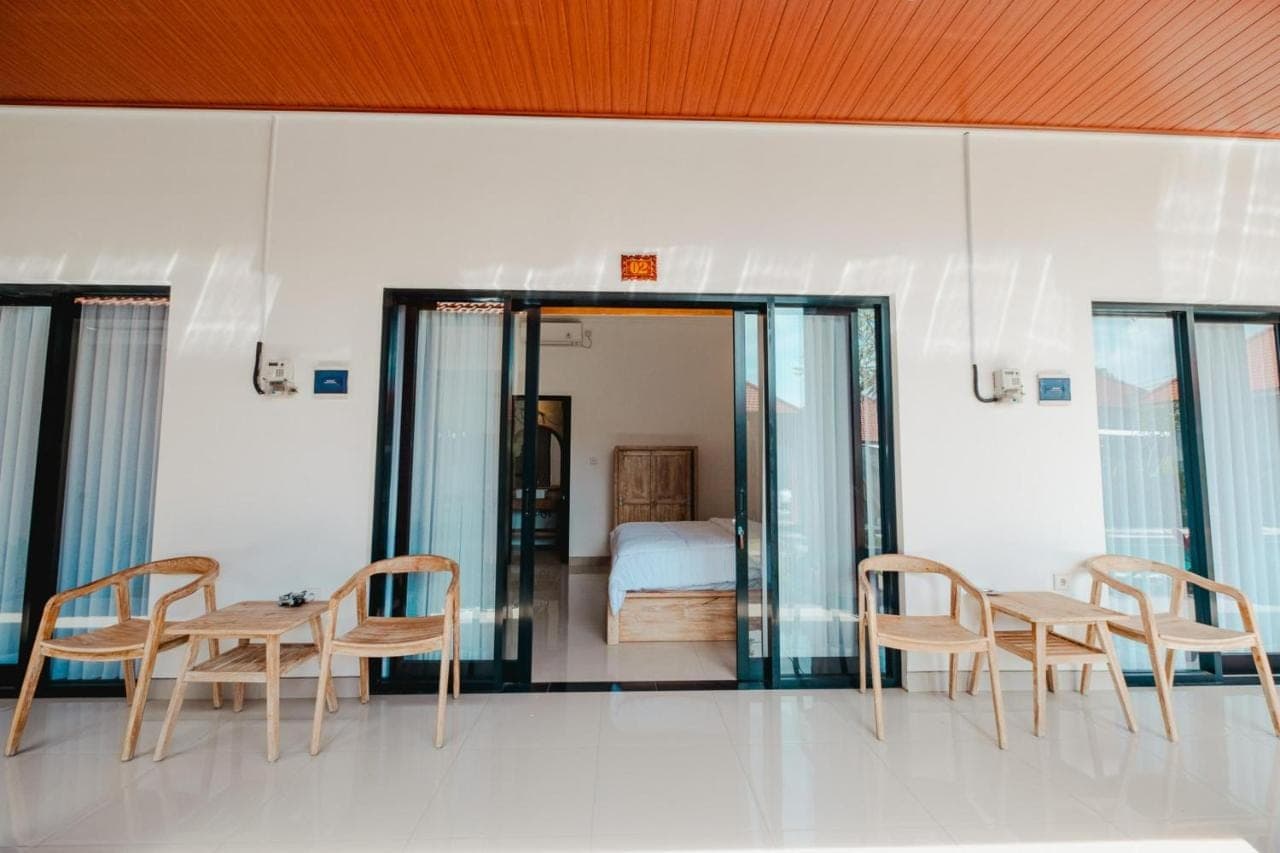 a room with a table and chairs and a bed at Kubu Dangin Guest House Kerobokan in Seminyak