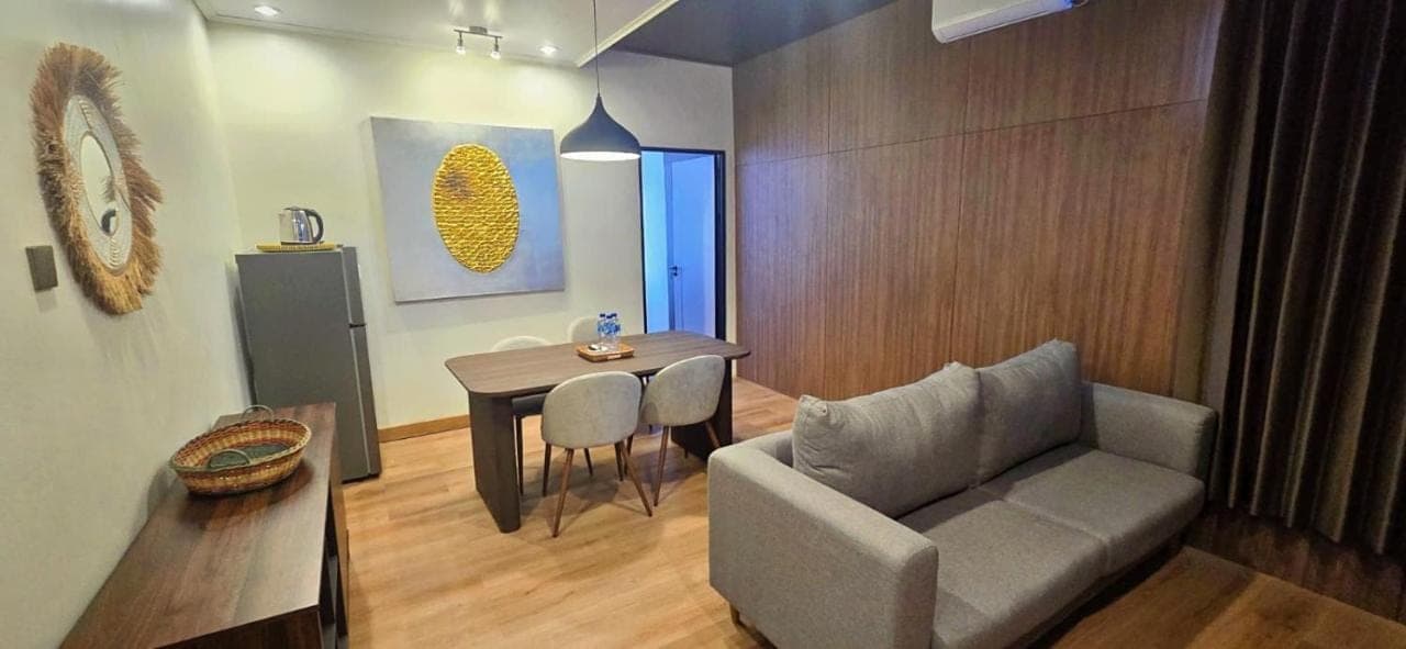a living room with a couch and a table at Stana Puri Gopa Hotel in Sanur