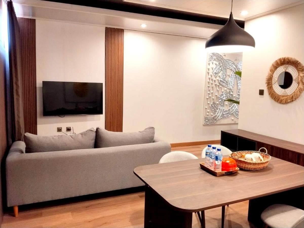 a living room with a couch and a table at Stana Puri Gopa Hotel in Sanur