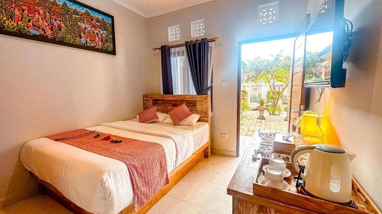 a bedroom with a bed and a large window at Adhi Homestay in Nusa Dua