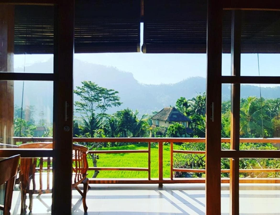 a room with a balcony with a view of a garden at Noka Homestay in Sidemen