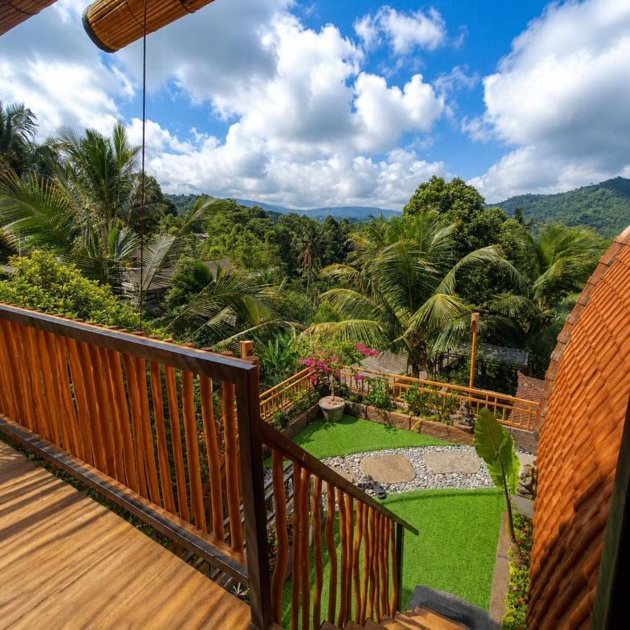 a balcony with a view of a garden at Kubu Dangin Ogang Guest House in Sidemen