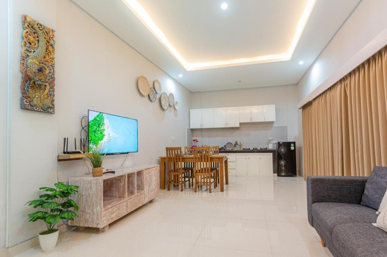 a living room with a couch and a kitchen at Kubu Ramah Suite Canggu in Canggu