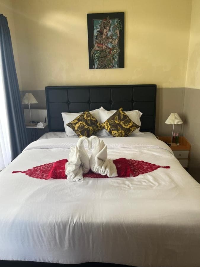 a bed with a stuffed animal on top of it at Wayan Bola Homestay in Sidemen
