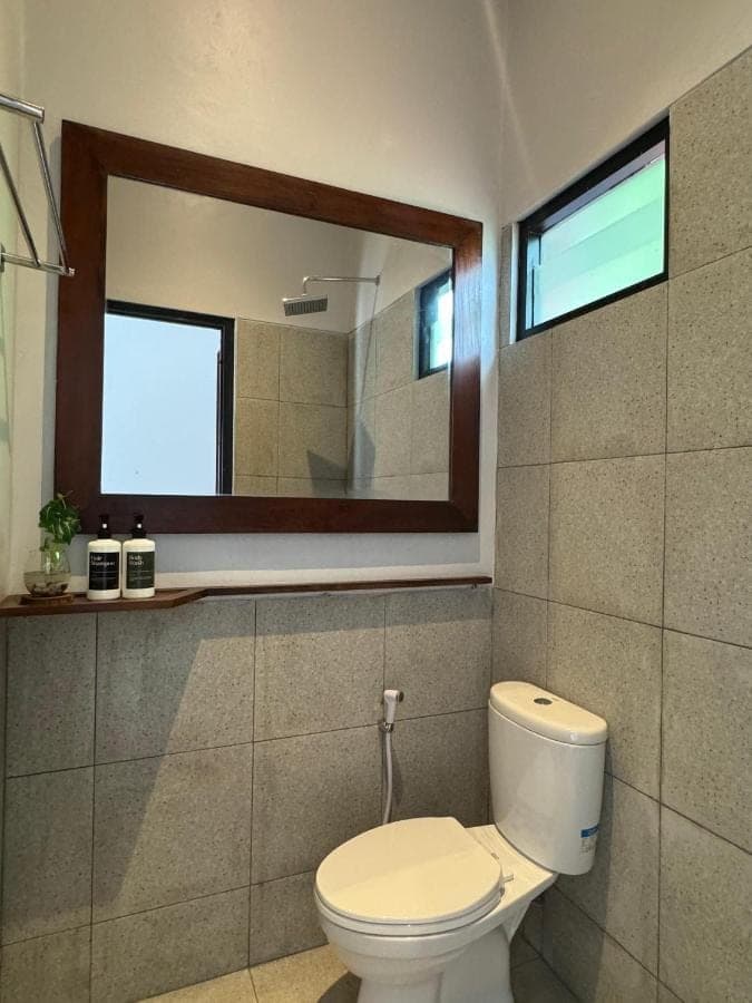 a bathroom with a toilet and a mirror at WISH Stay-Surf-Relax in Uluwatu